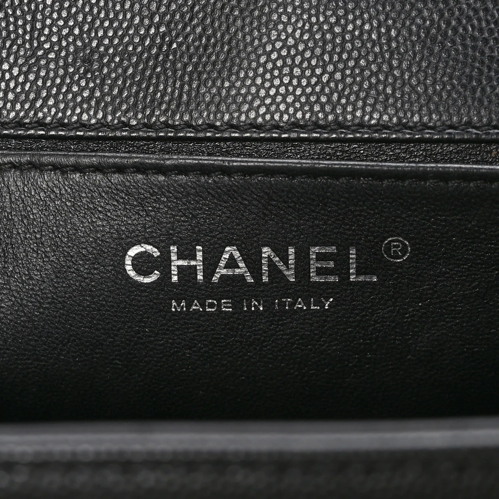 Close-up of the Boy push-lock closure and chain hardware on the black caviar leather Medium Boy Flap