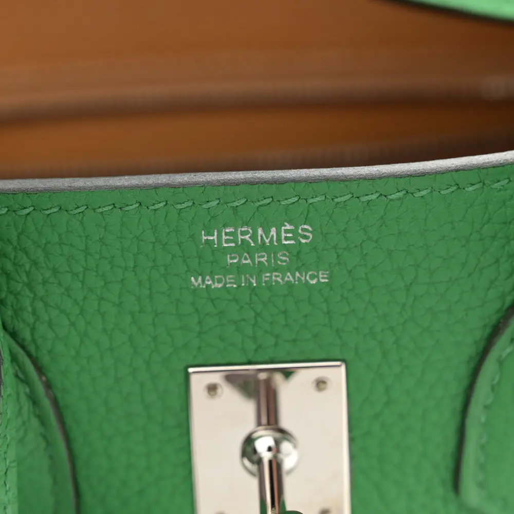 Close-up of the Herme$ Birkin 25 lock, gold hardware, and signature sangles straps