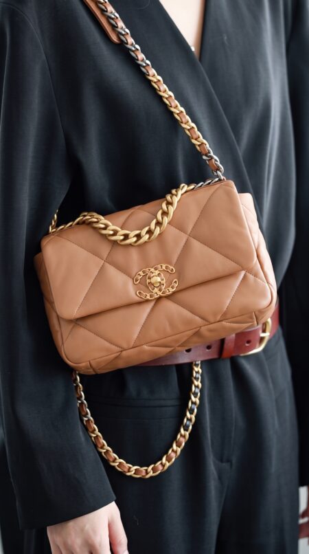 Model carrying the brown lambskin Medium Ch@nel 19 Flap with mixed aged gold chain strap
