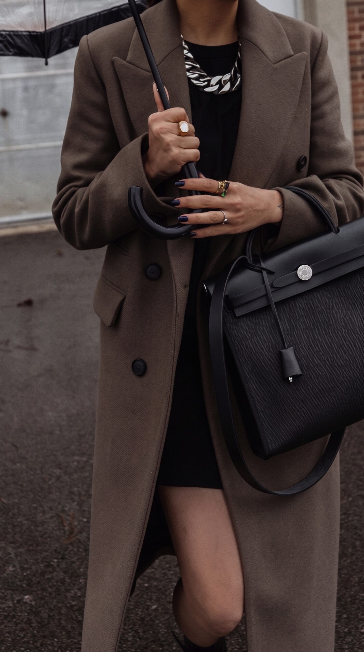 Model carrying the Herme$ Herbag Zip PM 31 Black/Ecru Toile H Vache Hunter Leather with Palladium hardware