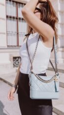Model carrying the light blue aged calfskin Gabrielle Hobo with mixed-metal chain strap