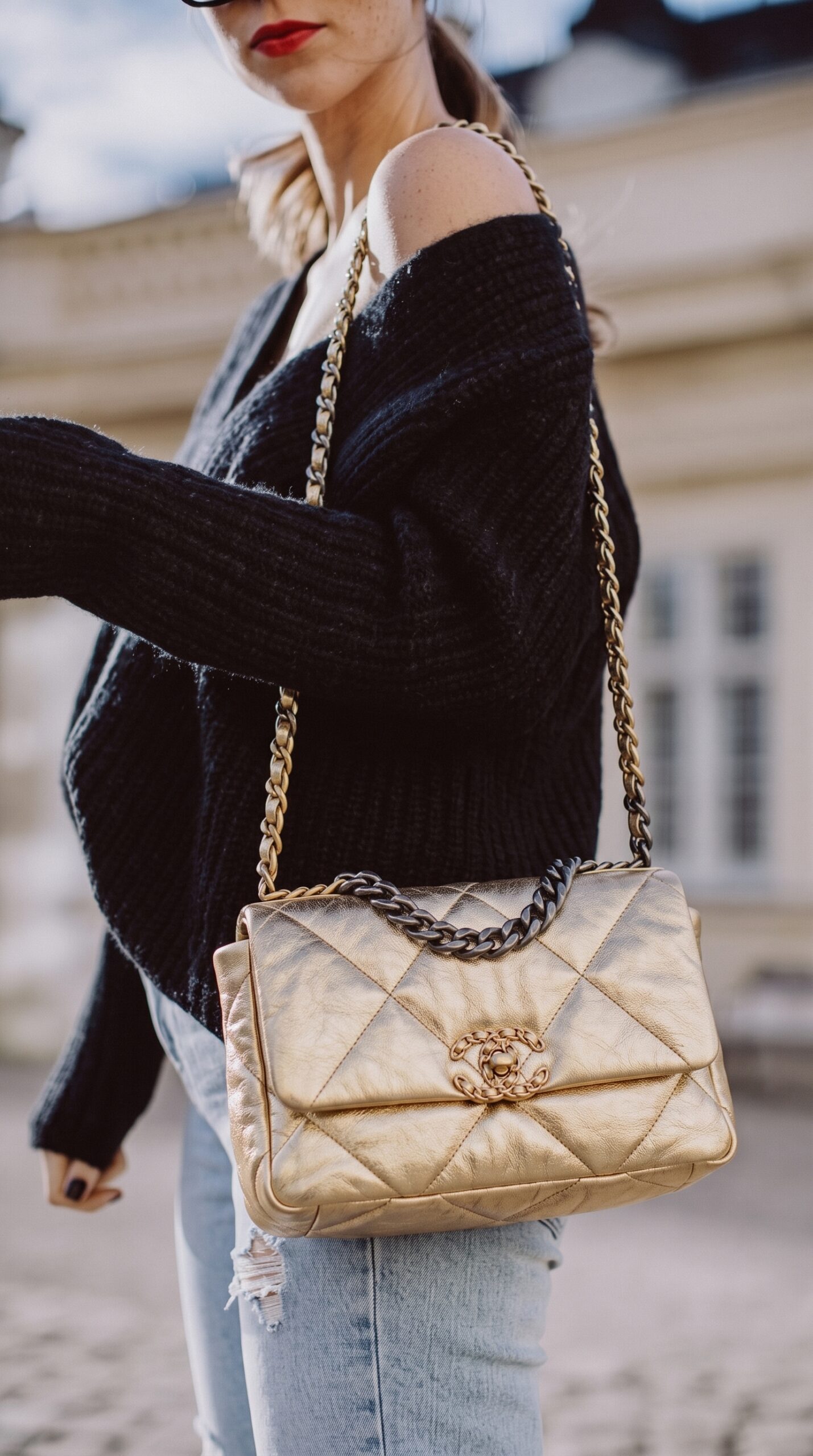 Model carrying the gold metallic lambskin Ch@nel Medium 19 Flap with mixed-metal chain-link strap