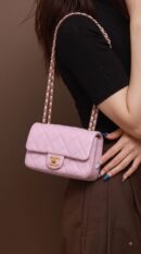 Model carrying the lilac lambskin Ch@nel Pearl Small Flap with pearl-accented aged gold chain strap
