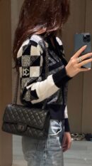Model carrying the metallic black Ch@nel 2.55 Reissue 225 Flap with ruthenium chain straps