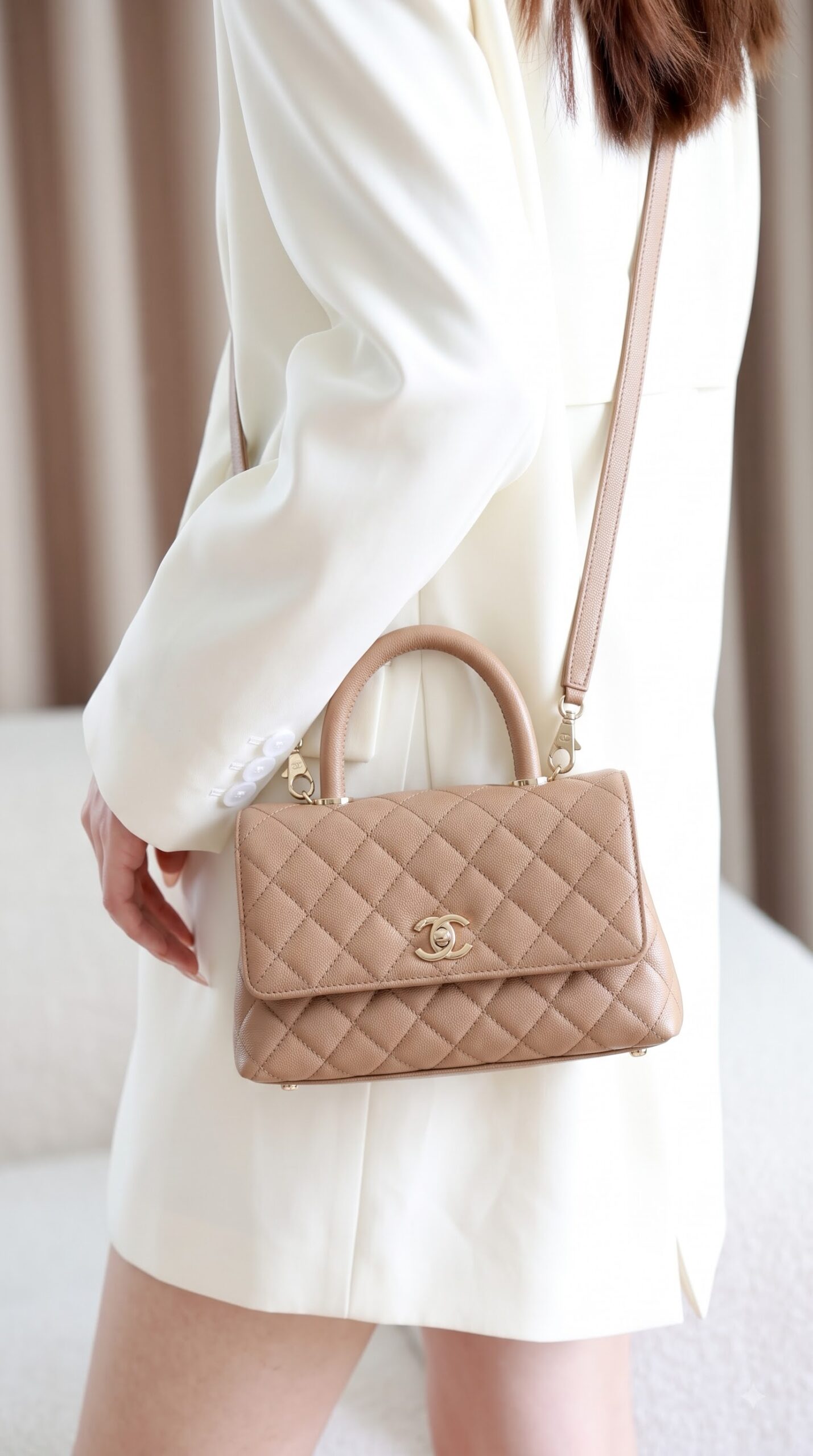 Model carrying the brown caviar leather Ch@nel Mini Coco Handle Flap with gold chain strap