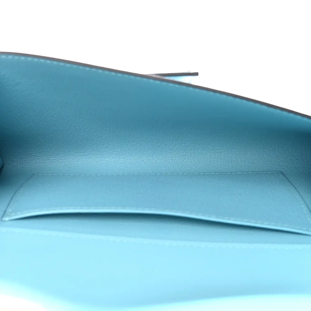 Interior view of the Herme$ Bleu Atoll Tadelakt Leather Medor 23 Clutch with smooth leather lining
