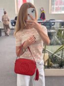 Model carrying the Pebbled Calfskin Small Soho Disco Bag in Tabasco Red