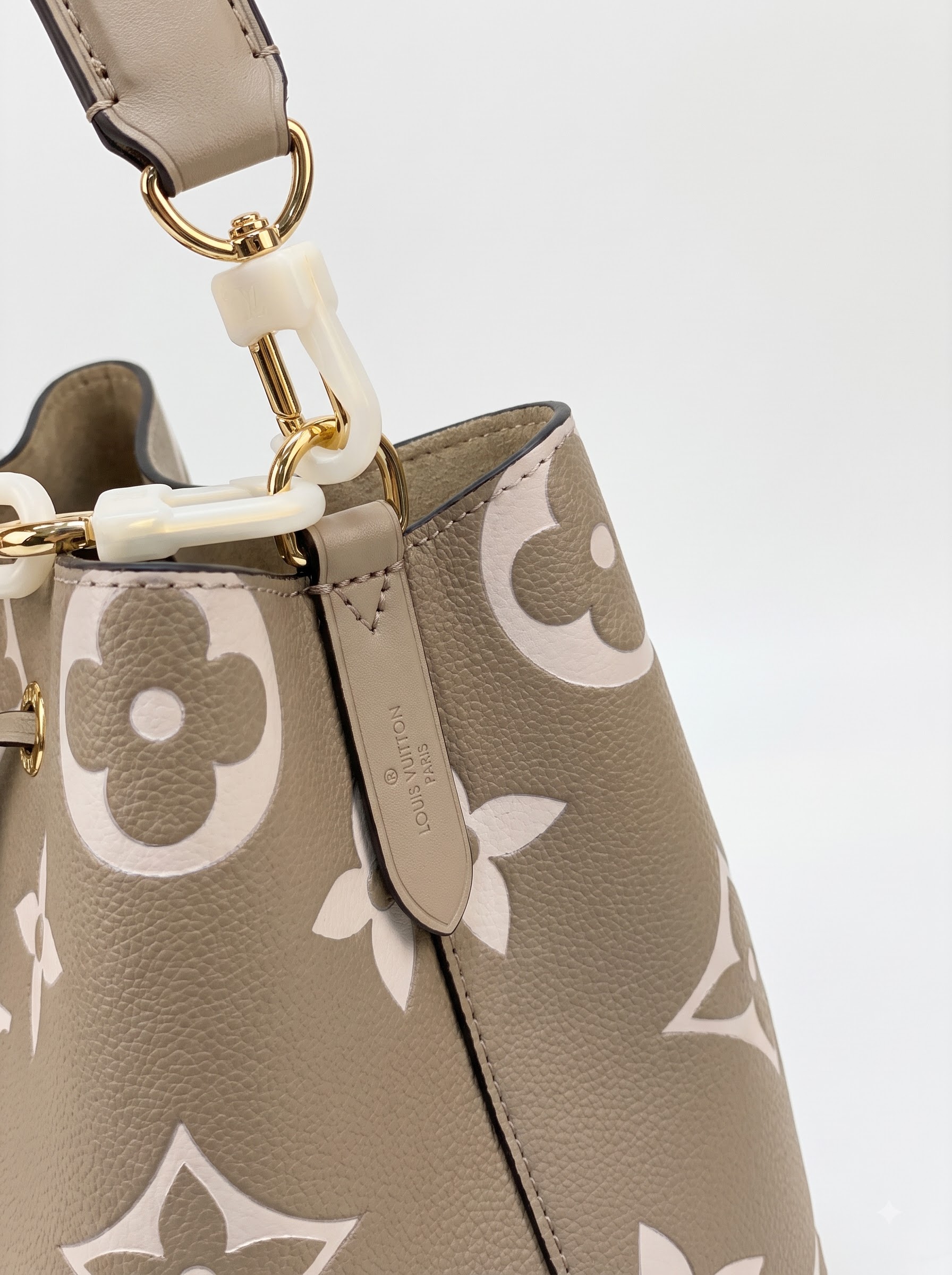 Close-up of the embossed Monogram pattern, drawstring closure, and gold-tone hardware on the NéoNoé MM