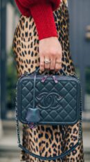 Model carrying the dark turquoise iridescent caviar leather CC Filigree Vanity Case with iridescent chain strap