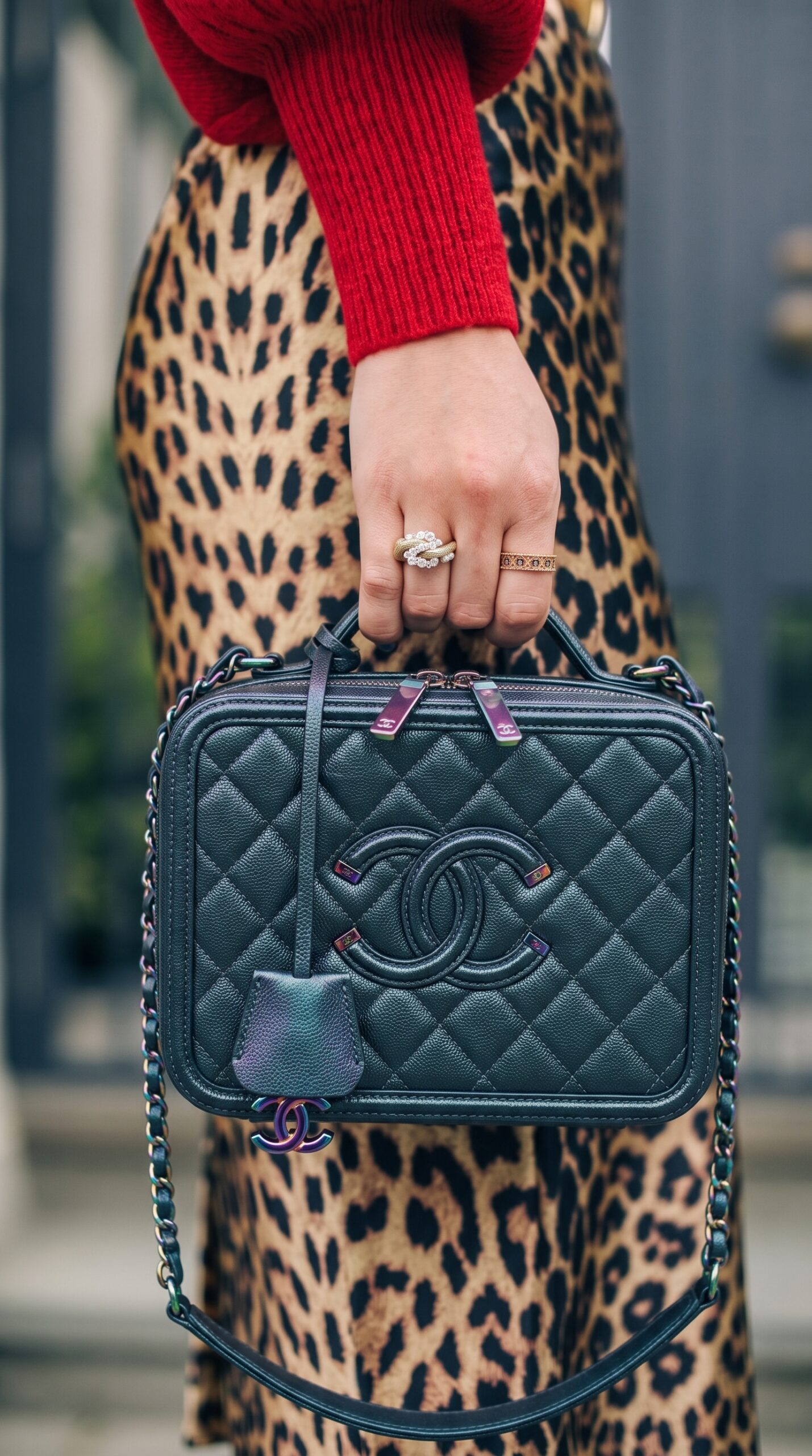 Model carrying the dark turquoise iridescent caviar leather CC Filigree Vanity Case with iridescent chain strap