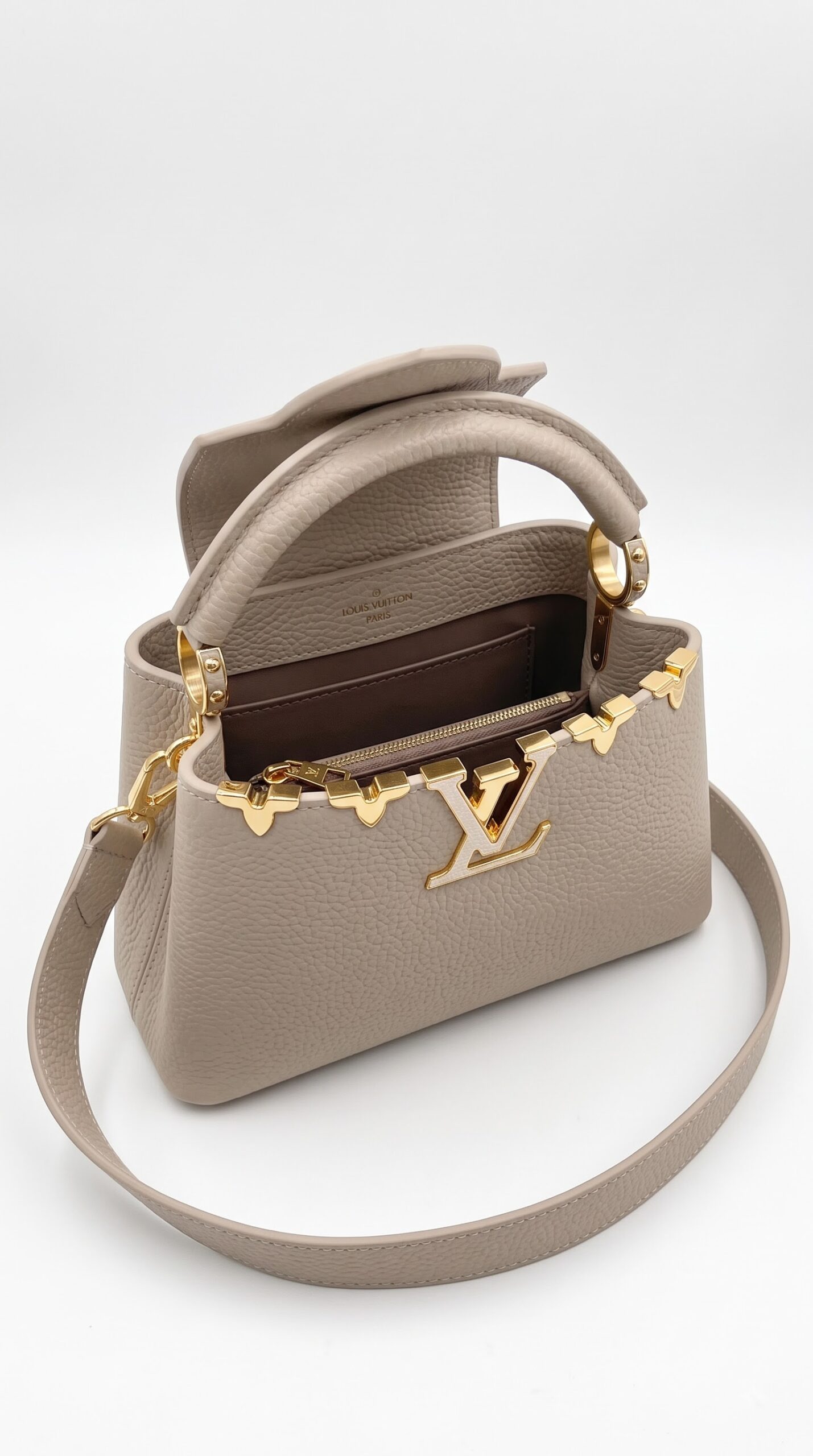 Interior view of the Galet taupe Lou!S Vuiton Capucines Mini showing its leather lining and storage pockets
