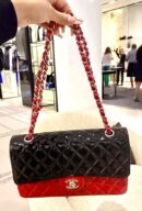 Model carrying the red and black Ch@nel Mini Rectangular Flap with silver-tone chain strap