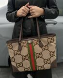 Model carrying the camel and ebony Gucc! Jumbo GG Ophidia Shopping Tote