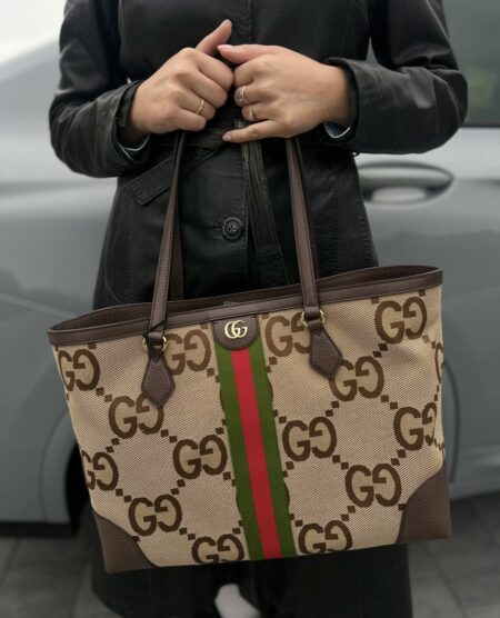 Model carrying the camel and ebony Gucc! Jumbo GG Ophidia Shopping Tote