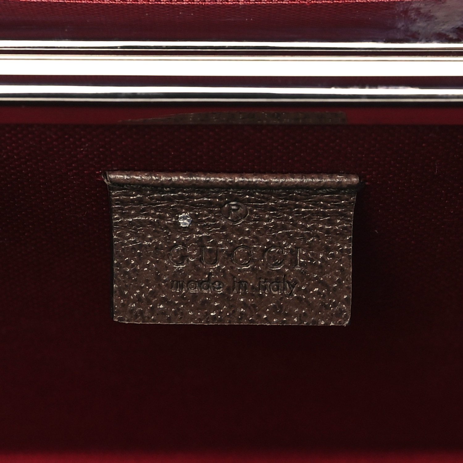 Close-up of the GG Supreme monogram, brown leather corner caps, bamboo handle, and hardware