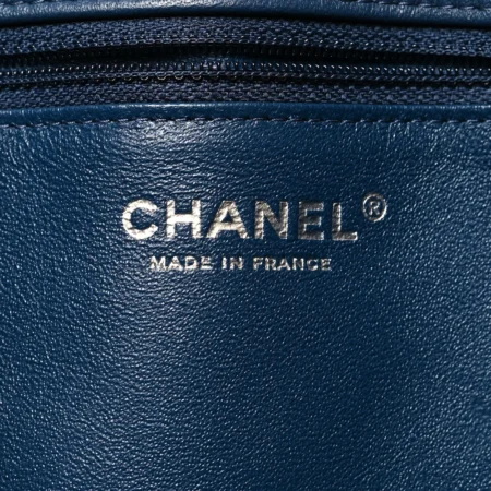 Close-up of the silver tone CC turn-lock on the navy Ch@nel Flap Clutch