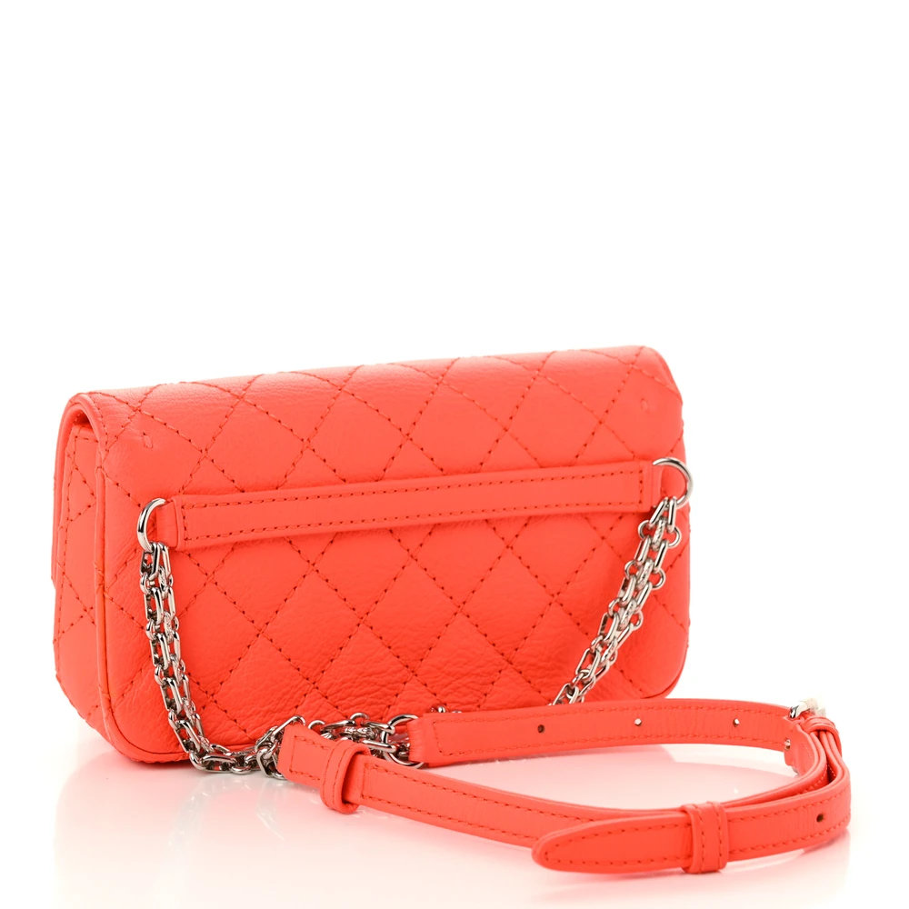 Back view of the vibrant orange Ch@nel Reissue Flap Belt Bag with silver-tone chain waist strap