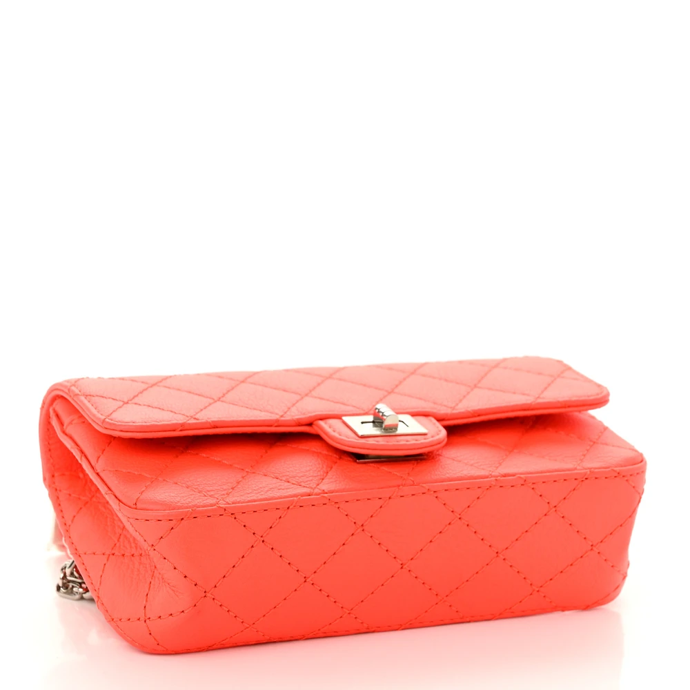 Bottom view of the vibrant orange Ch@nel Reissue Flap Belt Bag with silver-tone chain waist strap