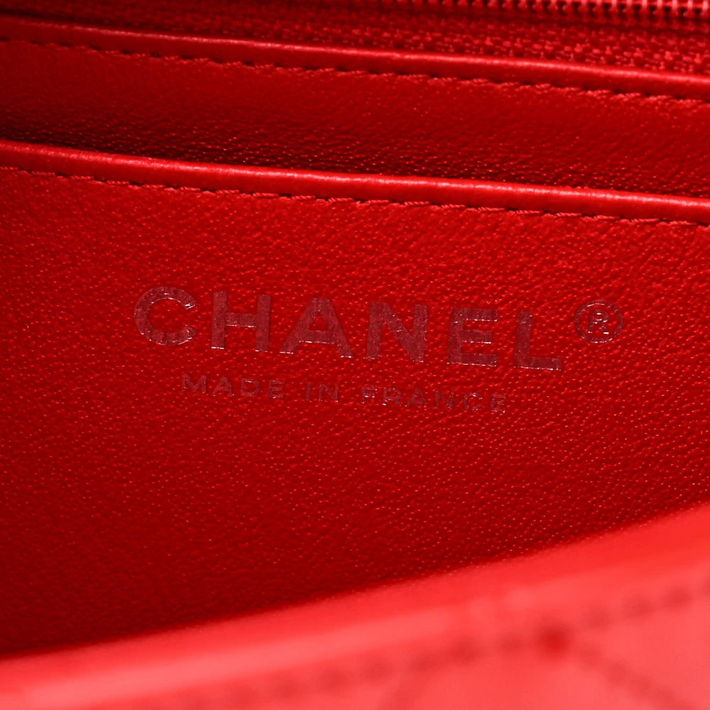 Close-up of the silver-tone CC turn-lock and chain-link hardware on the red and black Ch@nel Mini Flap
