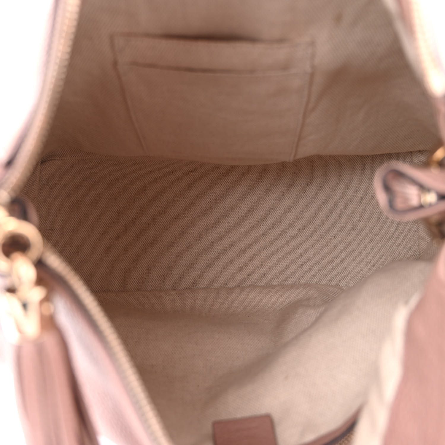 Interior view of the Camelia beige Gucc! Soho Hobo showing its beige canvas-style lining, zipper pocket, and patch pockets