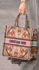 Model carrying the D!0r Large Book Tote multicolor embroidered canvas with double top handles