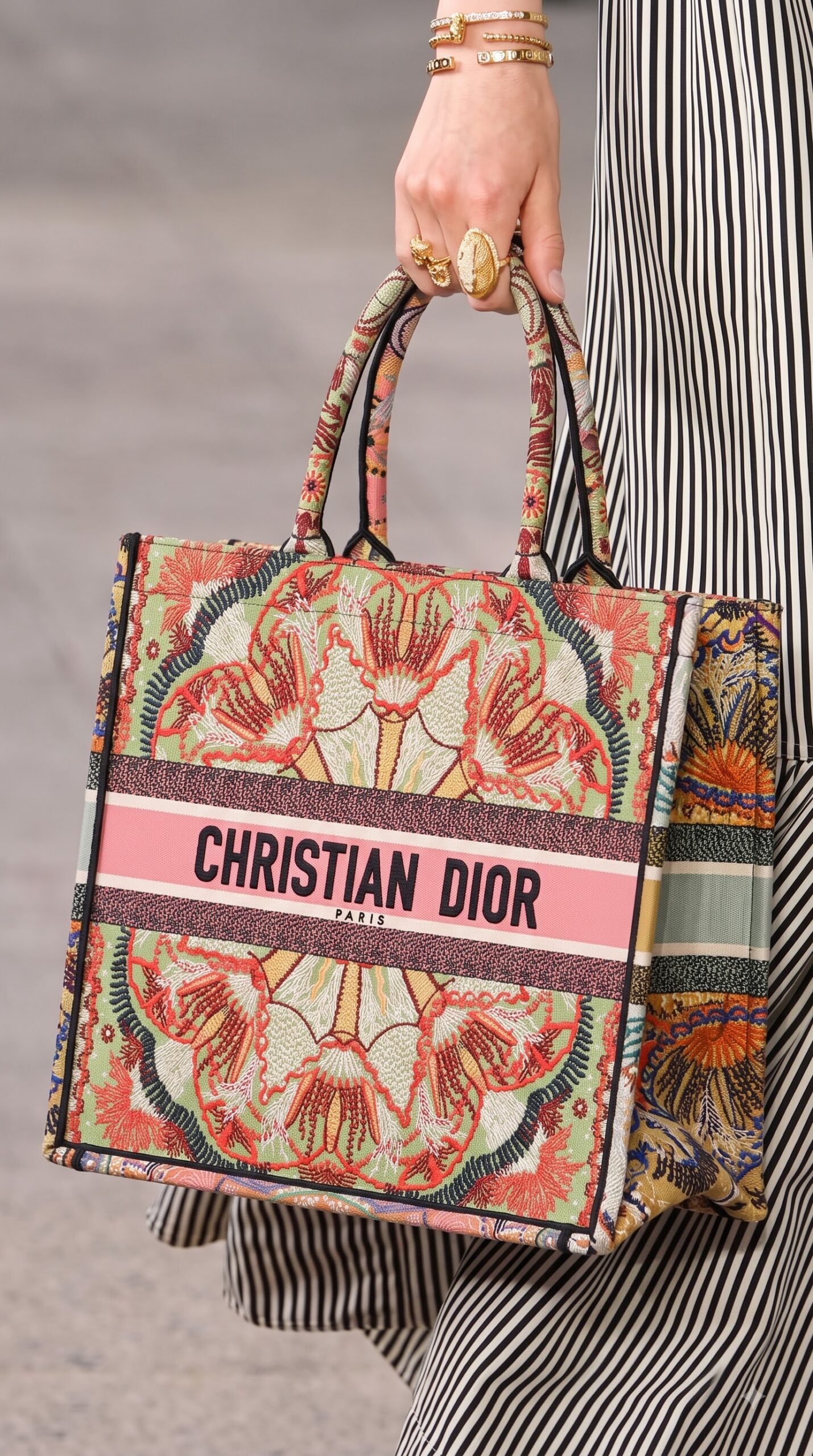 Model carrying the D!0r Large Book Tote multicolor embroidered canvas with double top handles