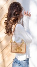 Model carrying the natural raffia D!0r Micro Caro Bag with chain shoulder strap