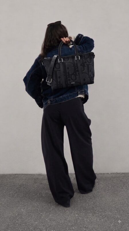 Model carrying the black Maxi D!0r Oblique jacquard D!0r Weekender 25 Bag