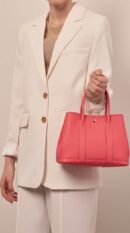 Model carrying the Bougainvillea Herme$ Garden Party 36 tote