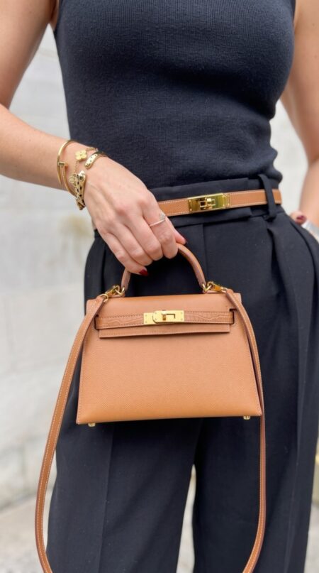 Model carrying the brown Herme$ Mini Kelly Sellier Touch 20 with adjustable shoulder strap