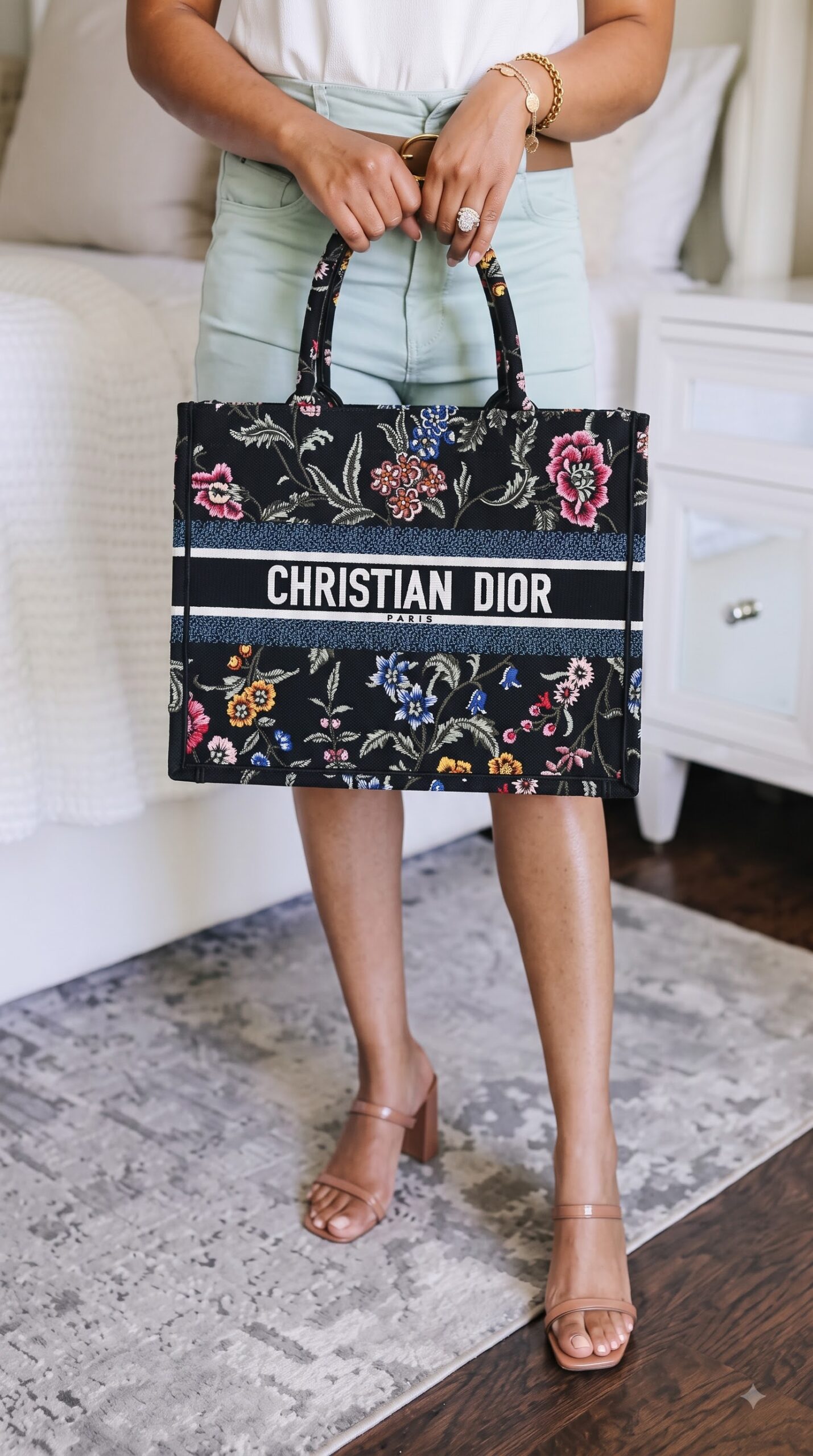 Model carrying the natural raffia D!0r Medium Book Tote with floral embroidery