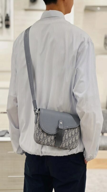 Model carrying the D!0r Small Saddle Messenger Bag with adjustable shoulder strap