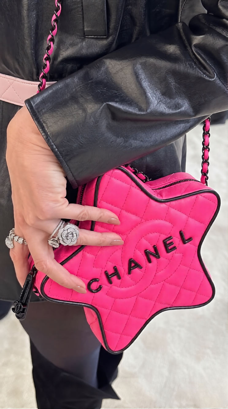 Model carrying the vibrant fuchsia Ch@nel Walk of Fame Star Bag with black chain strap