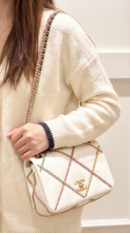 Model carrying the white Small Entwined Ch@nel Chain Flap with multicoloured chain strap