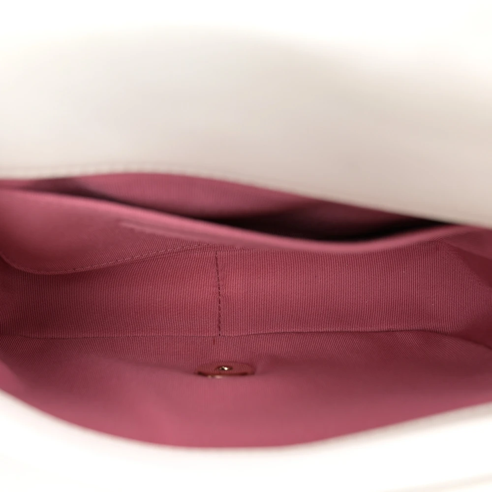Interior view of the white Ch@nel Chain Flap Small Entwined showing its pink fabric lining and patch pocket