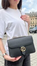 Model carrying the black grained calfskin Small Interlocking G Shoulder Bag