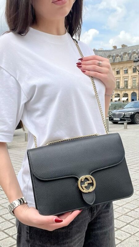 Model carrying the black grained calfskin Small Interlocking G Shoulder Bag
