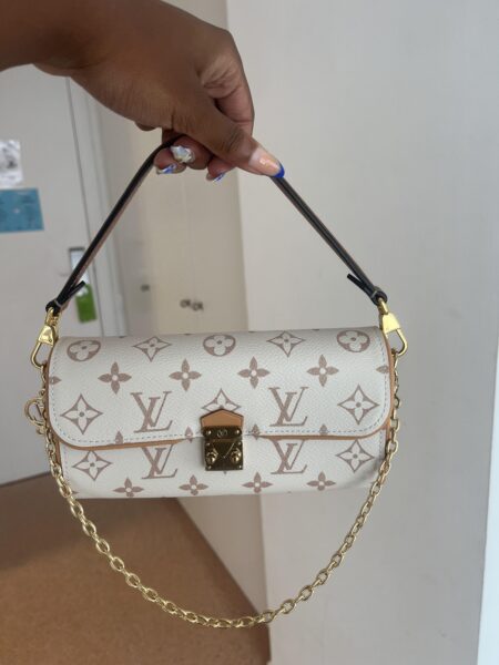 Model carrying the cream and beige Lou!S Vuiton Pochette Camille