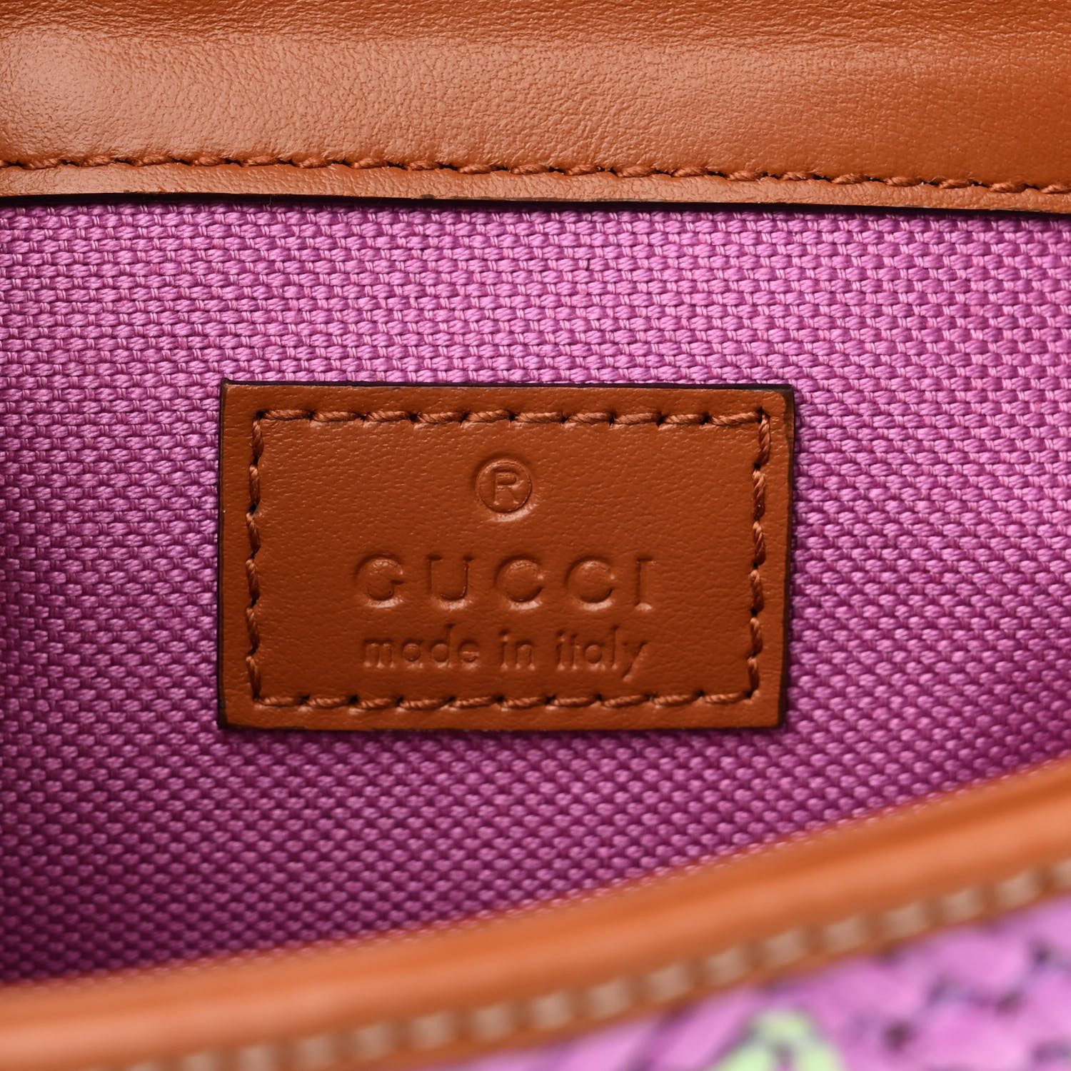 Close-up of the GG-inspired detail, woven raffia texture, brown leather trim, and chain strap