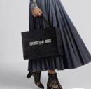 Model carrying the black and multicolour D!0r Medium Book Tote