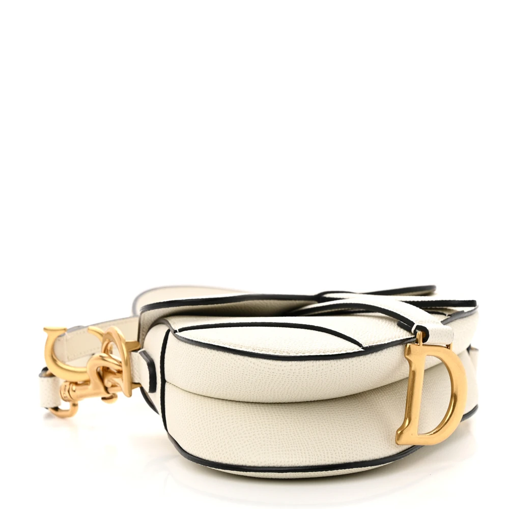 Bottom view of the white D!0r Saddle Bag with brass-tone accents