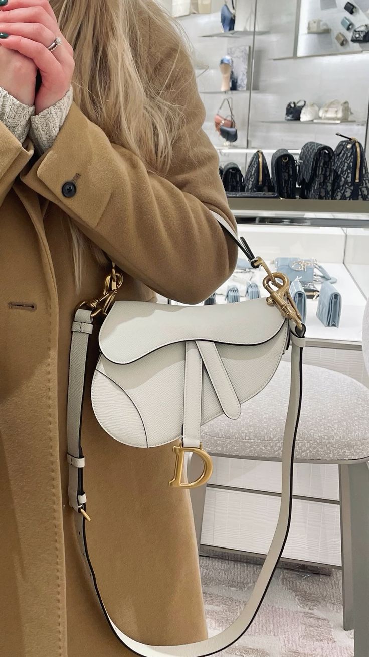 Model carrying the white D!0r Saddle Bag with adjustable shoulder strap