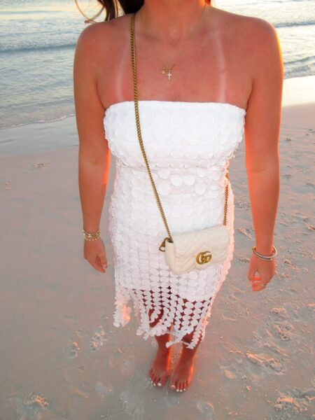 Model wearing the white Gucc! Super Mini GG Marmont Shoulder Bag with aged gold-tone chain strap