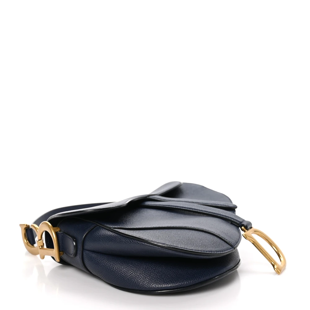 Bottom view of the navy blue grained calfskin D!0r Saddle Bag with its iconic curved silhouette