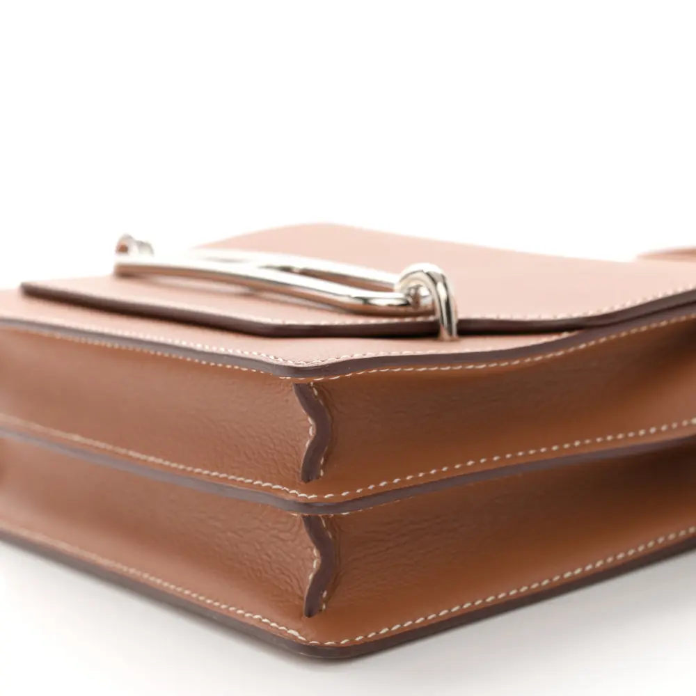Side view of the brown Evercolor leather Herme$ Mini Sac Roulis