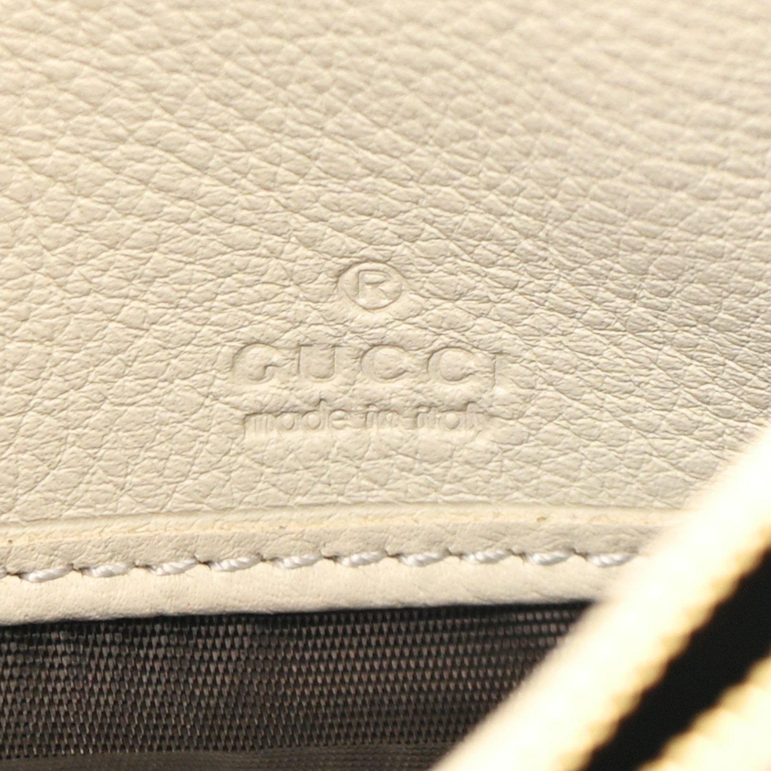 Close-up of the gold-tone interlocking GG logo and chain strap on the Mystic White Blondie Chain Wallet