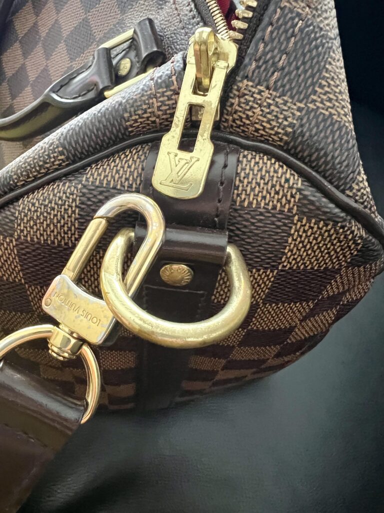 Brass-grade hardware on High quality super clone bags showing deep engraving and heavy zipper pull versus lightweight zinc hardware on cheap fake bag — hardware quality comparison