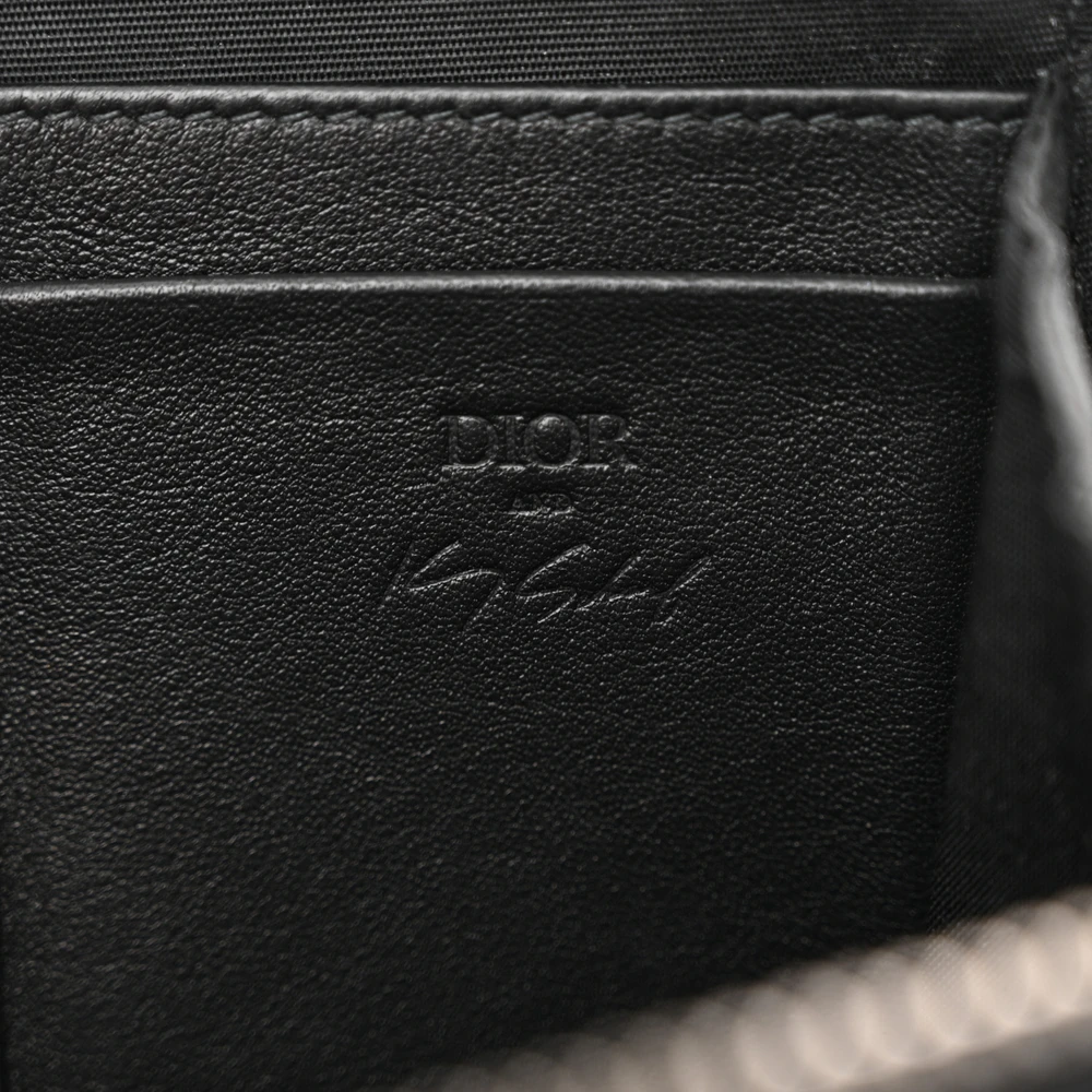 Close-up of the embroidered patches, adjustable canvas strap, and silver-tone hardware on the crossbody bag