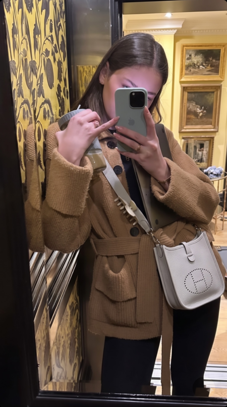Model carrying the Bleu Pale and Etain Herme$ Evelyne TPM crossbody bag