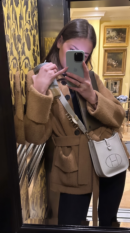 Model carrying the Bleu Pale and Etain Herme$ Evelyne TPM crossbody bag
